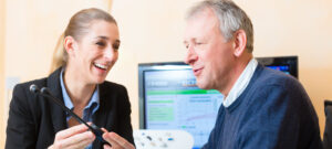 a man talking to a woman holding a device