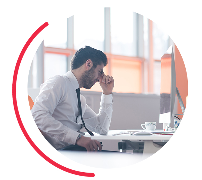 a business person holding their head at their desk