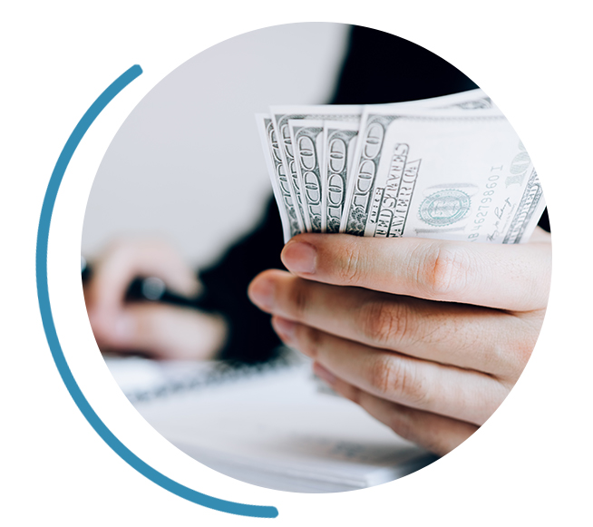 a person holding a fan of money and using a calculator