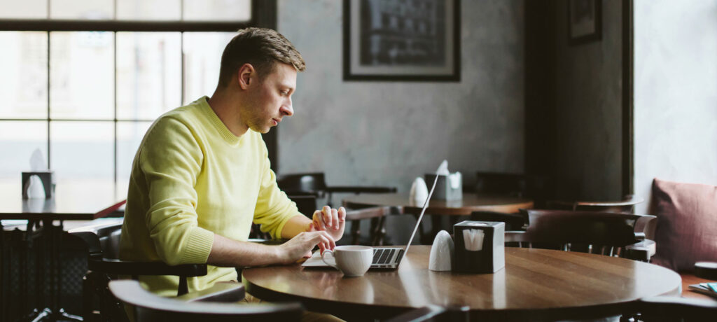 a man working on a laptop in a cafe