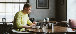 a man working on a laptop in a cafe