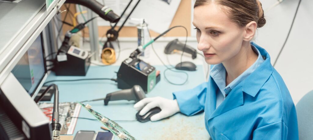 a computer engineering holding a computer board with tools around