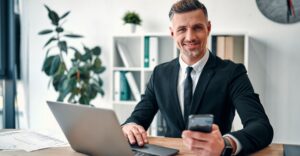Professional man using a laptop and smartphone