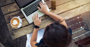 Top view of a woman on her laptop at a bench outside