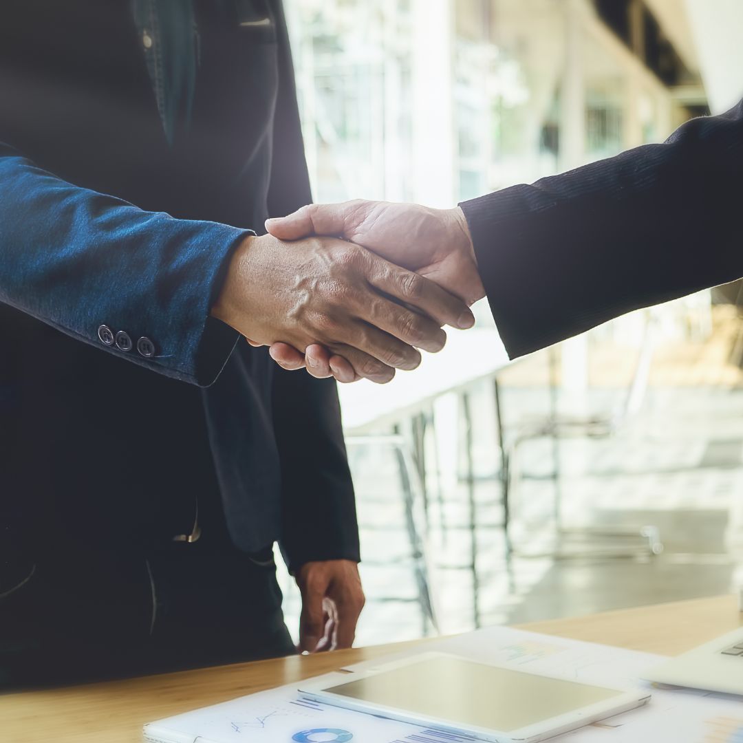 Shaking hands over desk