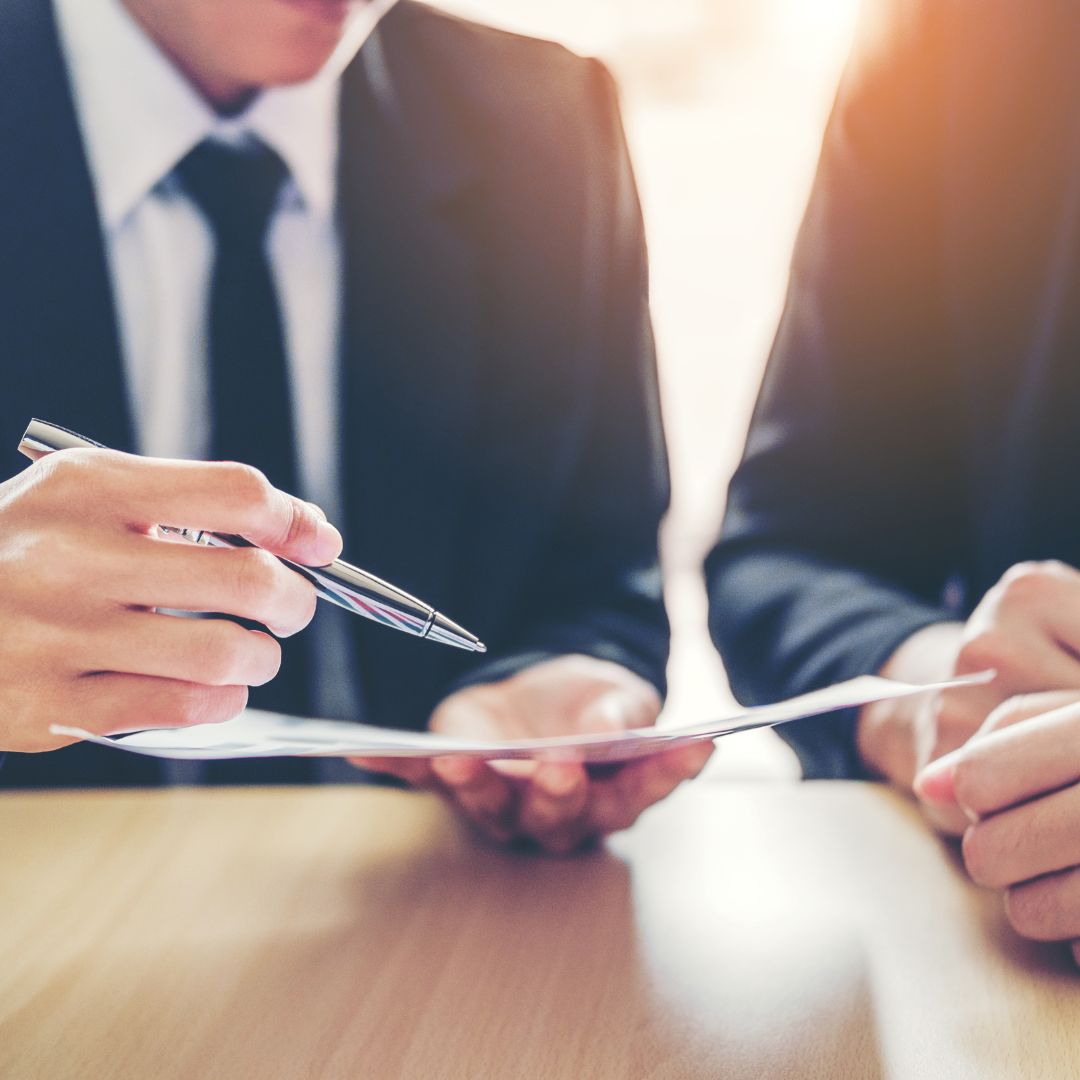 businessmen looking over a document with a pen