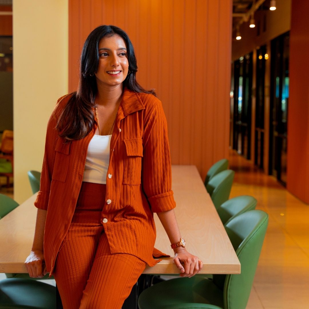 woman leans against conference table