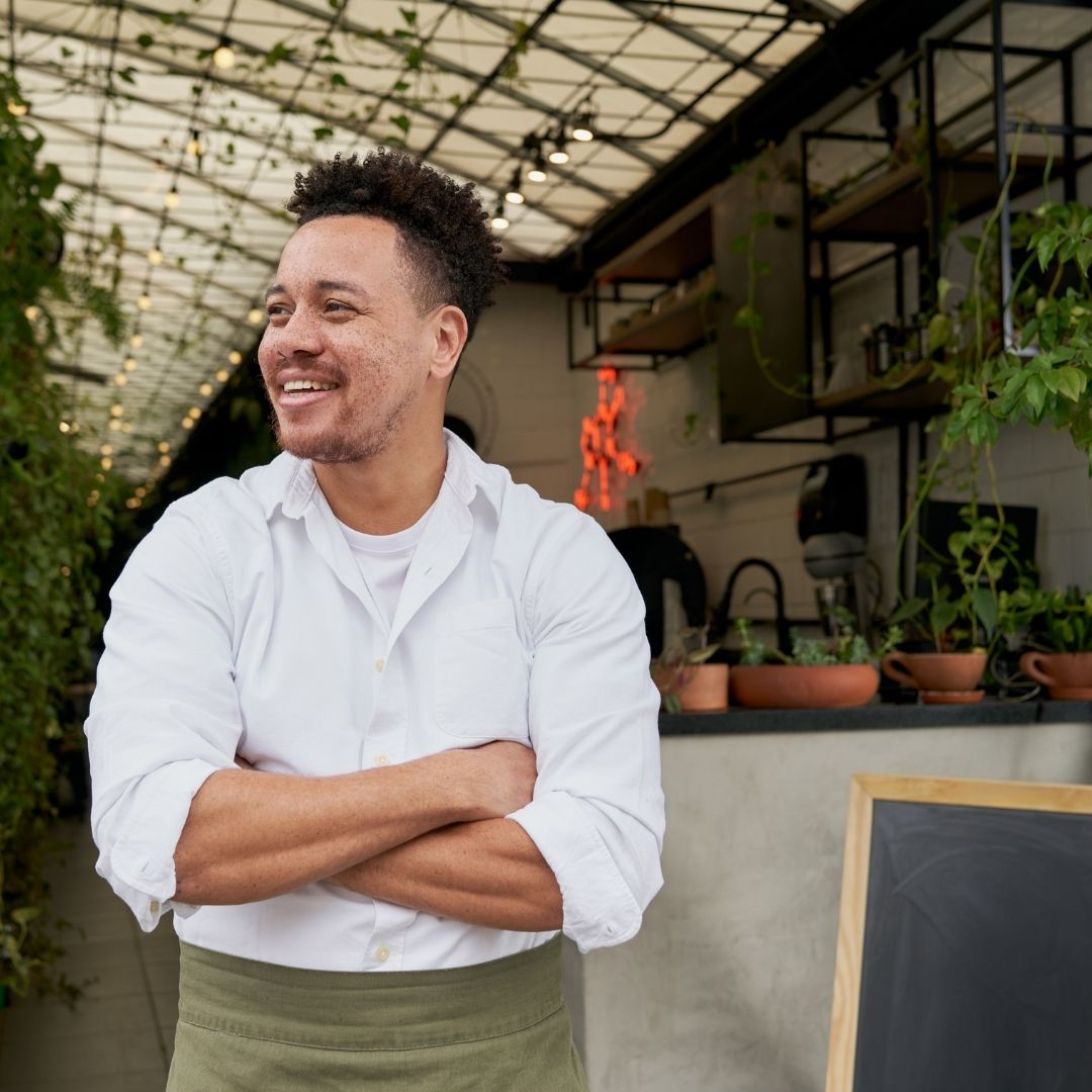man stands with arms folded in front of business