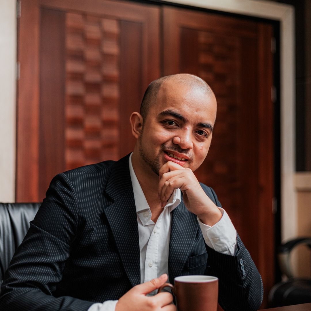 man in suit sits at table