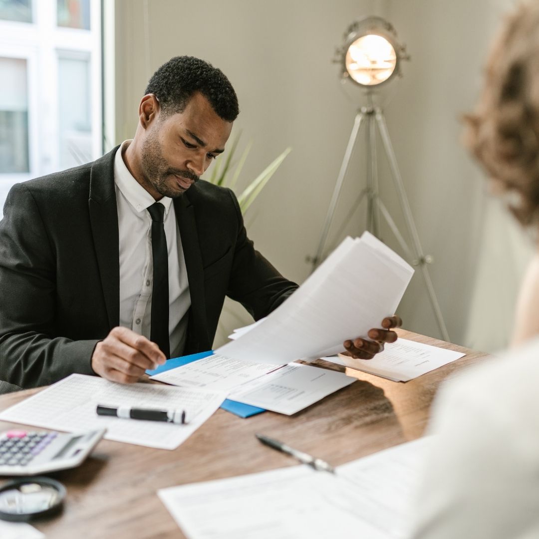 man in suit and tie holds papers