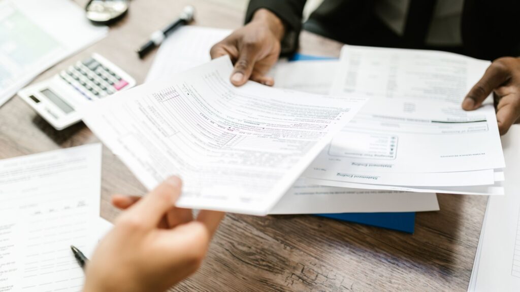 person hands paper over to someone across table