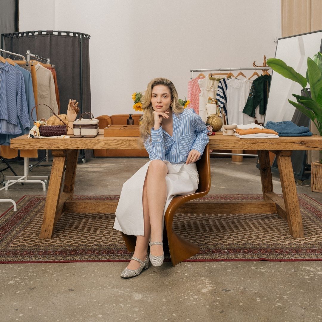 woman sits at table in clothes store